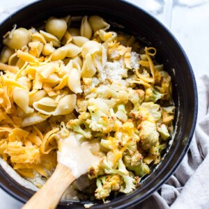Dutch Oven Mac and Cheese with Cauliflower and a wooden spoon in the dish.