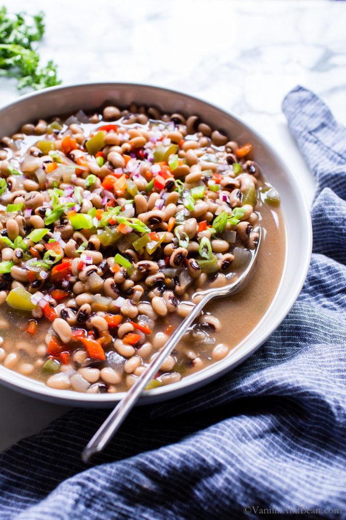 Vegetarian Black Eyed Peas in a large serving bowl with a serving spoon. 