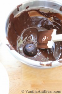 Bon bons dipped in a bowl of chocolate mixture for coating.