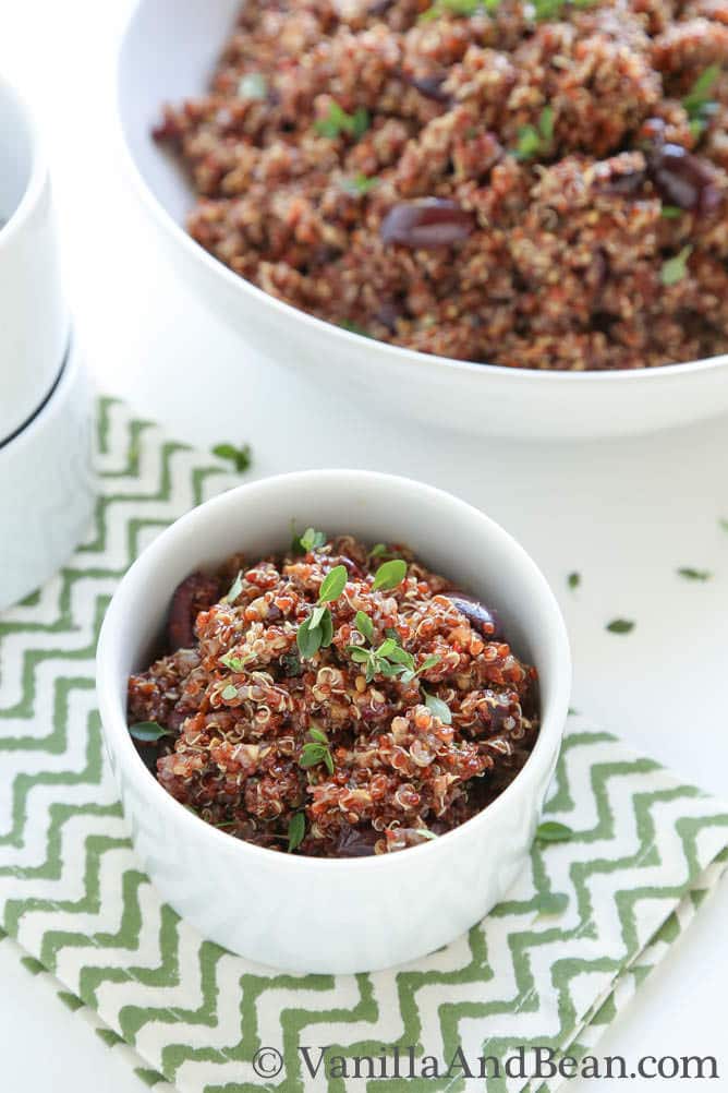 A small bowl and a serving bowl of roasted eggplant and quinoa salad