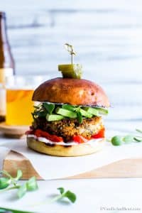 A Sweet Potato Burger setting on a cutting board ready to eat.
