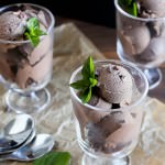 Scoops of dark chocolate ice cream in three glass cups.