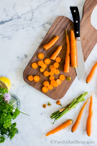 Chopped carrots on a cutting board with a knife. 