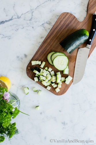 Chopping cucumbers on a cutting board. 