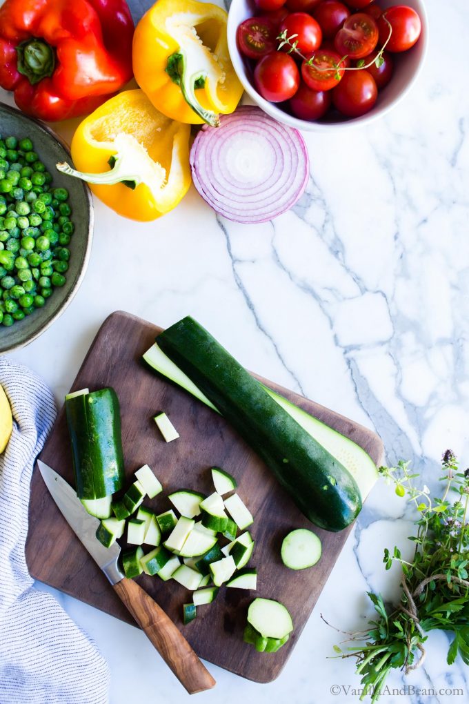 Slicing zucchini on a cutting board for a Quinoa Salad