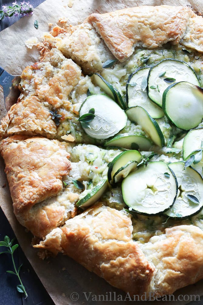 A galette with overlapping zucchini slices in the middle
