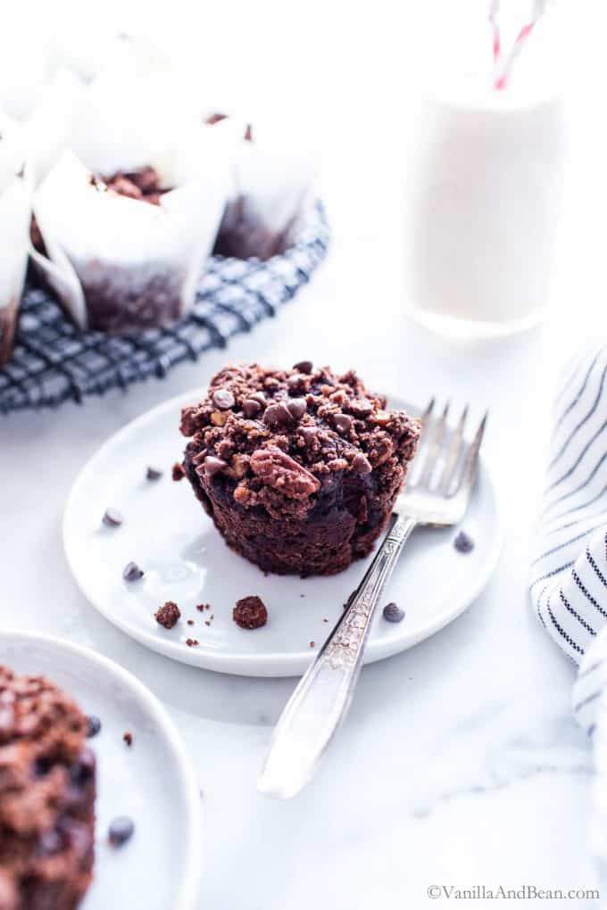 Zucchini Chocolate Muffins on plates, one with a fork, ready to eat.