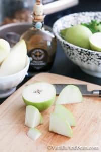 A sliced pear on a chopping board with knife