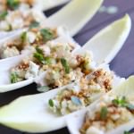 Endive leaves each with pear and blue cheese mixture topped with walnuts