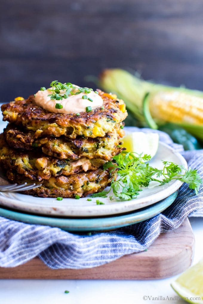 Corn and Zucchini Fritters stacked tall on a plate.
