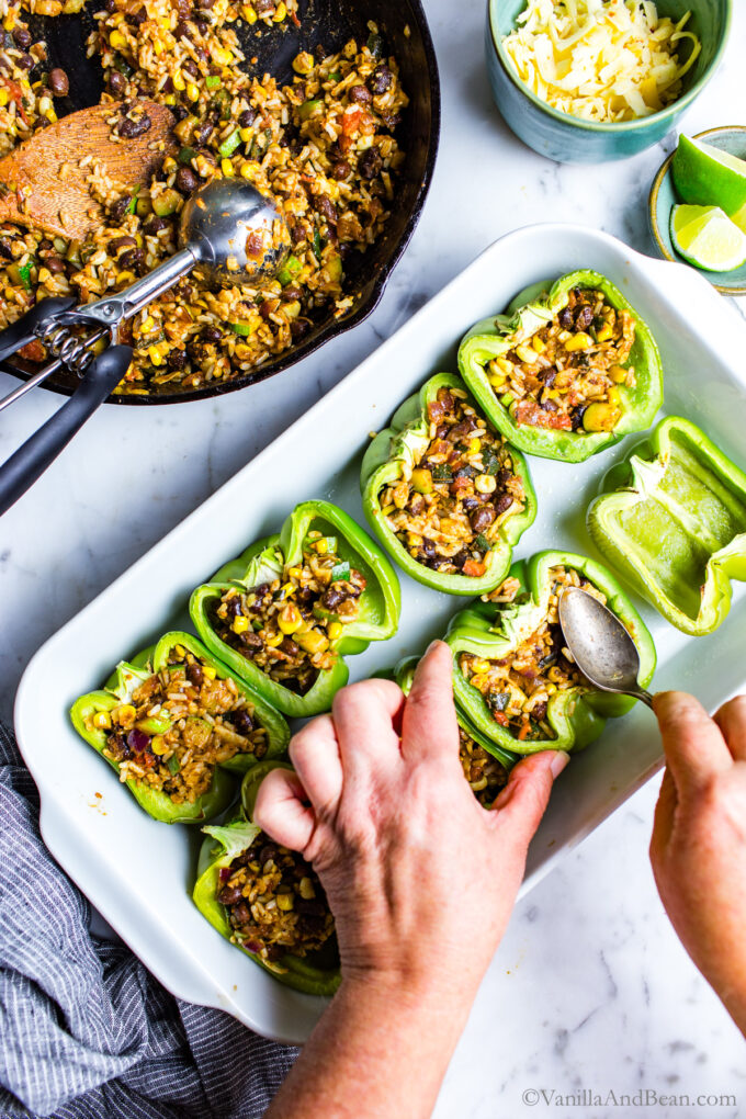 Stuffing Southwestern stuffed bell peppers and pressing the filling in wiht a spoon