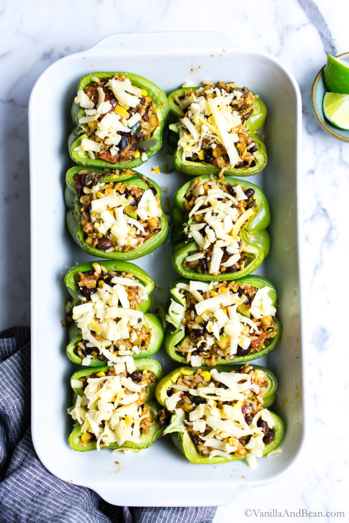 Stuffed peppers topped with cheese ready to bake.