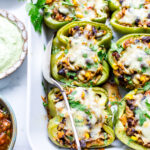 Southwestern stuffed bell peppers with all condiments on the side in a baker.