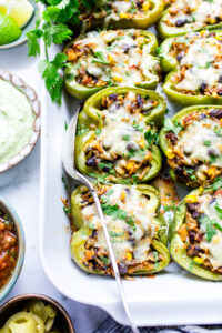 Southwestern stuffed bell peppers with all condiments on the side in a baker.