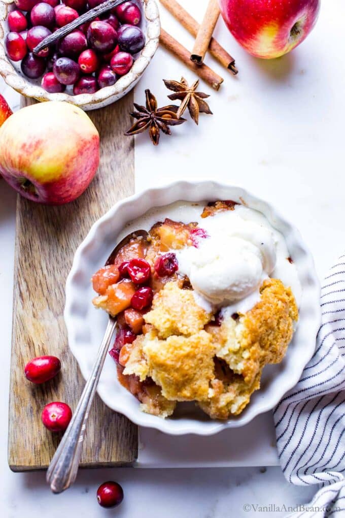 Cranberry apple dessert on a plate with ice cream.