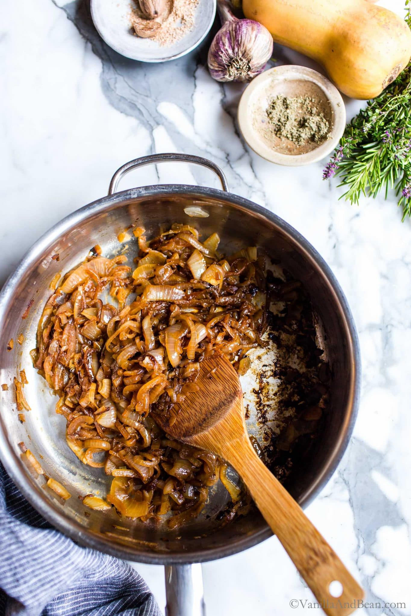 Caramelized onions in a pan with a spoon.