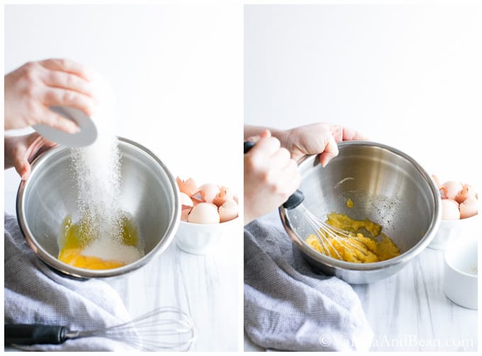 Sugar and egg yolks whisked in a stainless steel bowl.