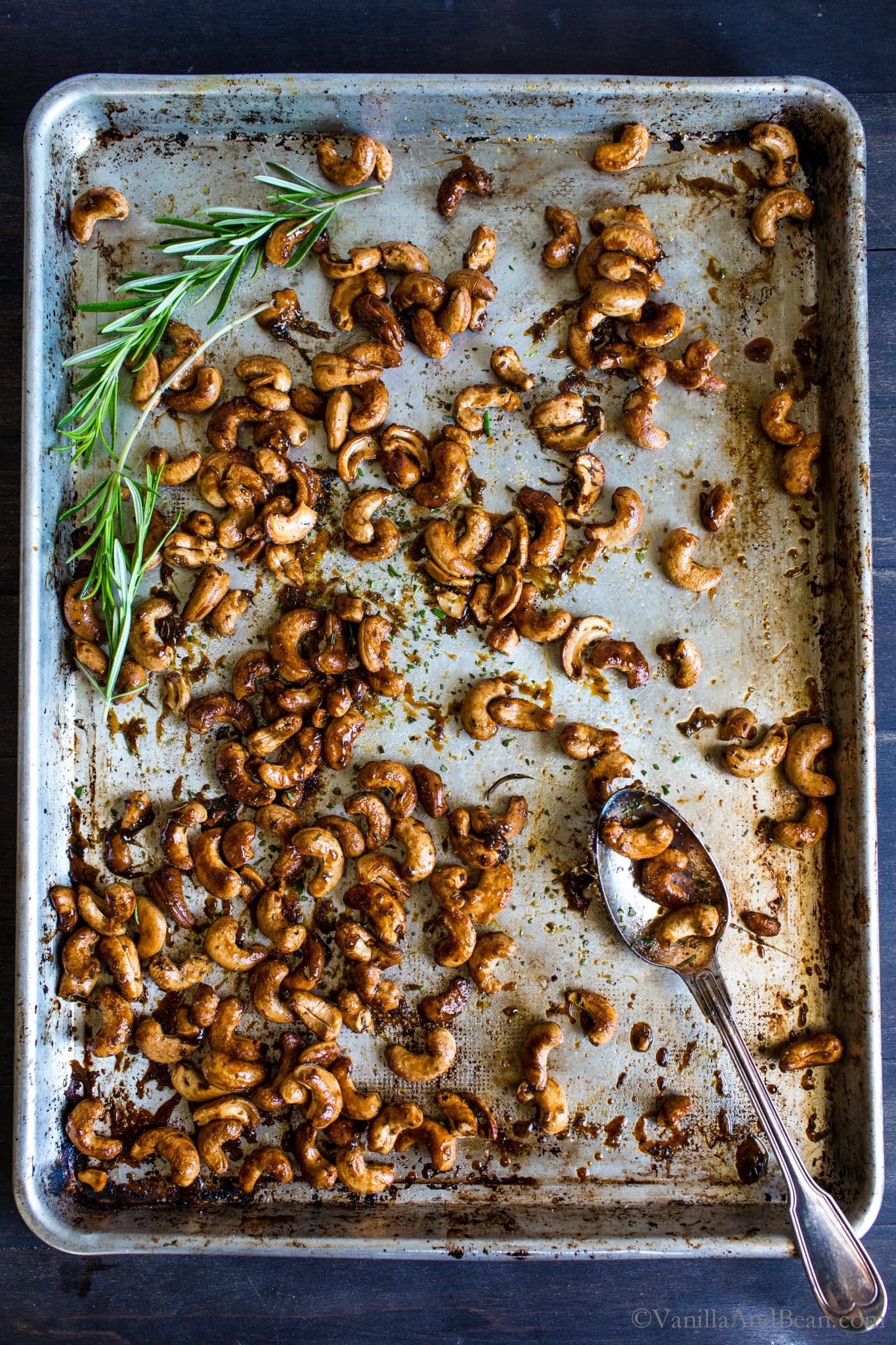 Sweet and Spicy Maple-Roasted Rosemary Cashews on a sheet pan ready to be shared. 