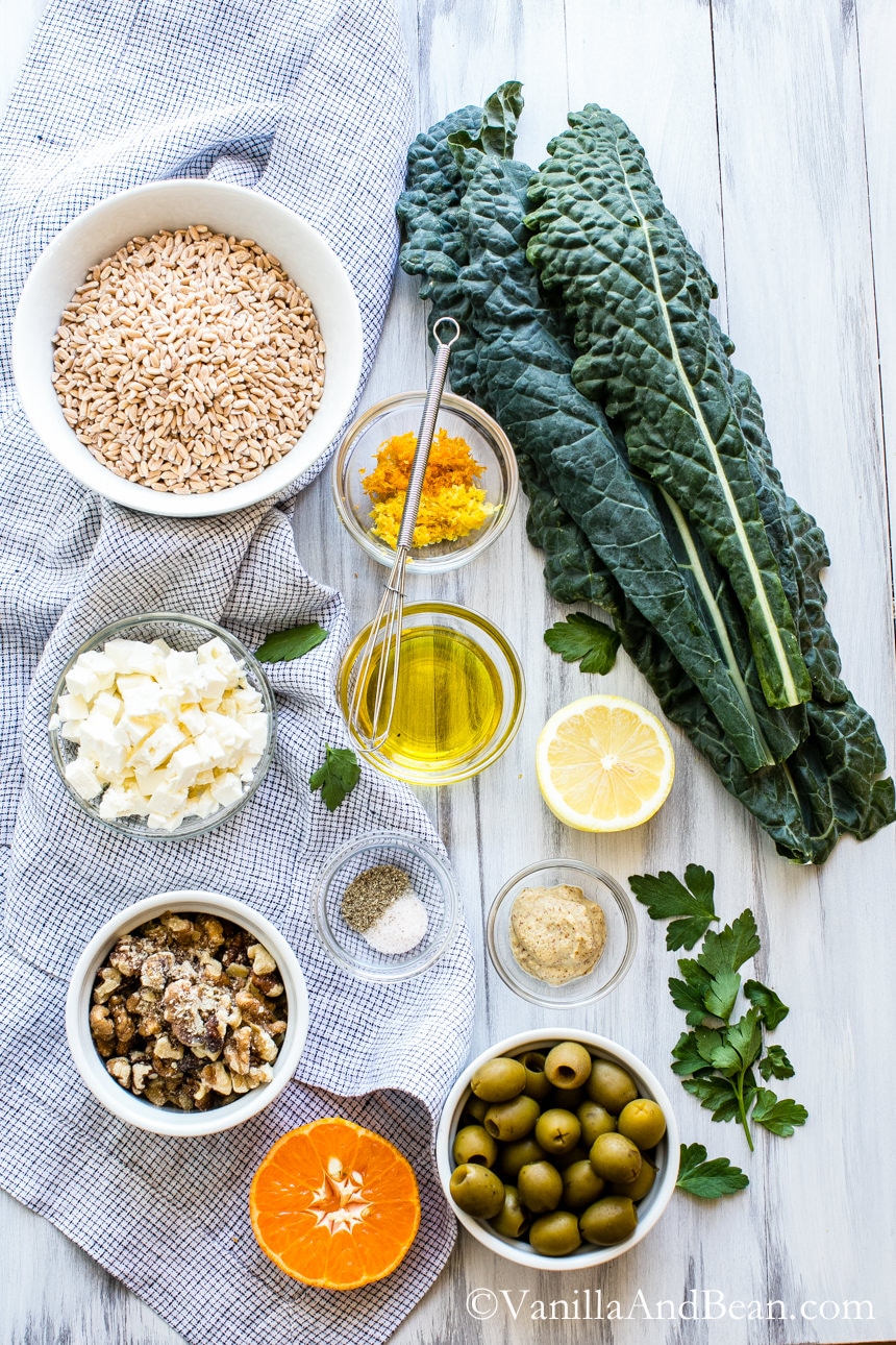 Ingredients of the Farro, Kale and Olive Salad mostly laid out in bowls on a table