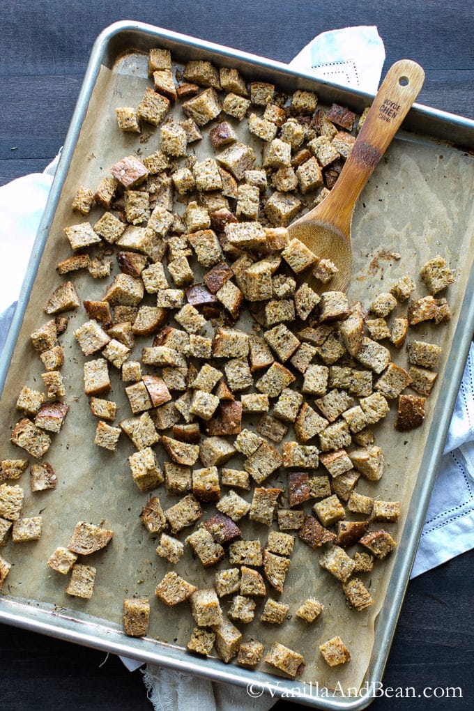 Herbed Coconut Oil Croutons spread on a tray lined with parchment paper.