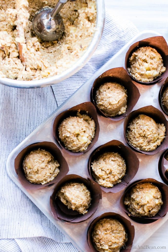 Scooping the Banana Oat Crunch Muffin Batter into muffin cups. 