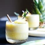 Fresh Pina Colada in glasses garnished with fresh pineapple.