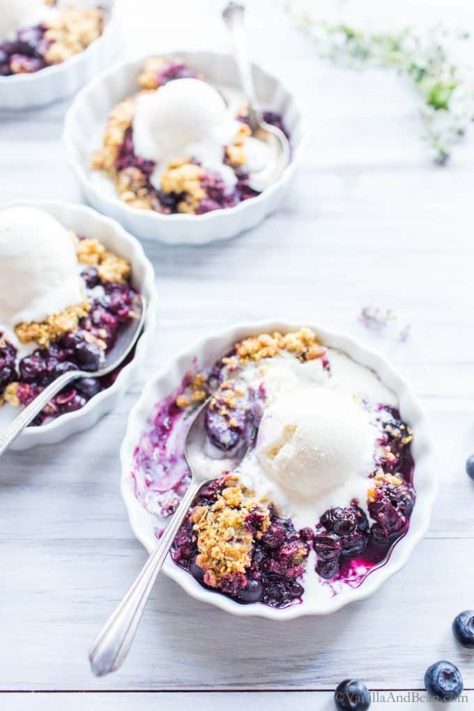 Blueberry Cornmeal Crisp in individual serving dishes with ice cream on top.