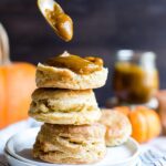 Slathering delicious pumpkin butter on the biscuit tower served in a white plate