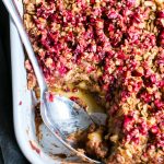 Apple Baked Oats with Cranberry Crumble in a pan with a spoon.