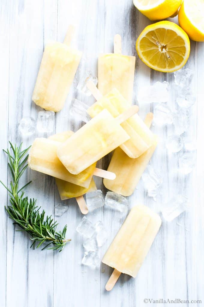 Lemon Popsicles on a courter top, stacked up with ice. 