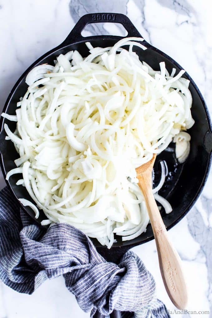 Sliced sweet onions in a saute pan.