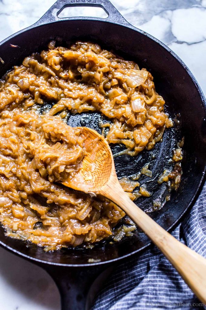 Boozy saucy sweet onions in a pan.
