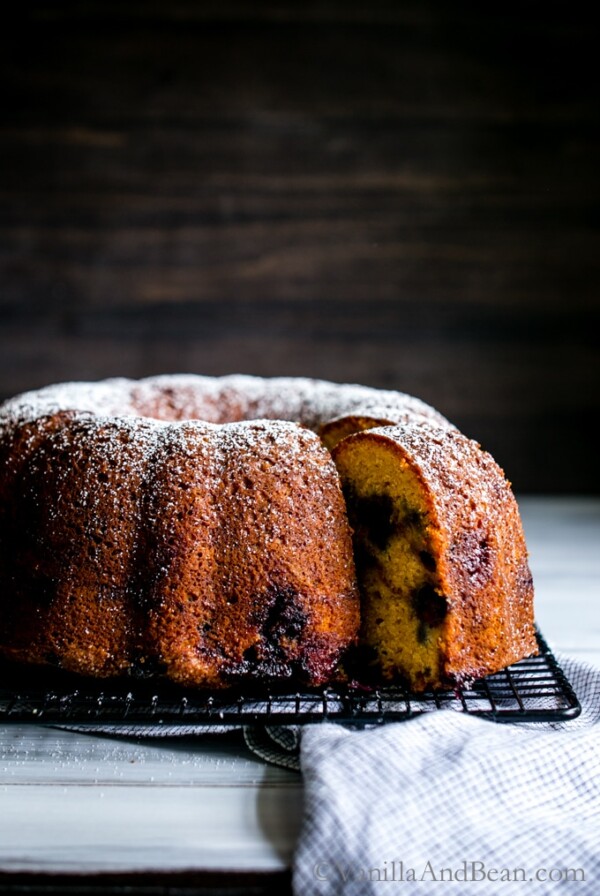 Blueberry Cinnamon Yogurt Coffee Cake sprinkled with powder sugar on a cooling rack.