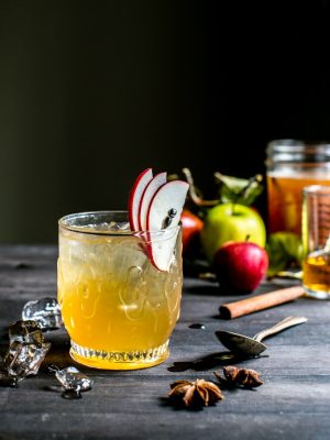 Bourbon Apple Cider Shrub Cocktail in a glass garnished with apple slices.