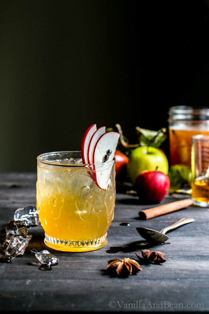 Bourbon Apple Cider Shrub Cocktail in a glass garnished with apple slices. 