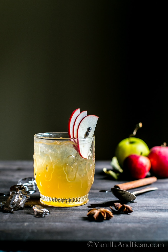Bourbon Apple Cider Shrub Cocktail in a glass garnished with apple slices. 