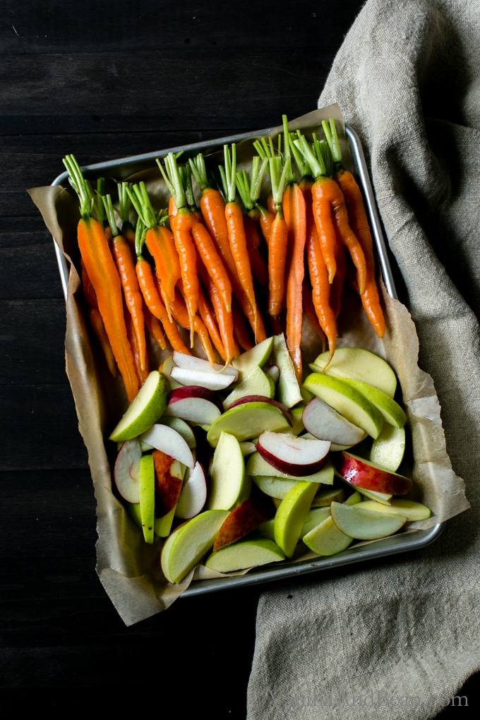 Carrots and sliced apples on a roasting pan. 
