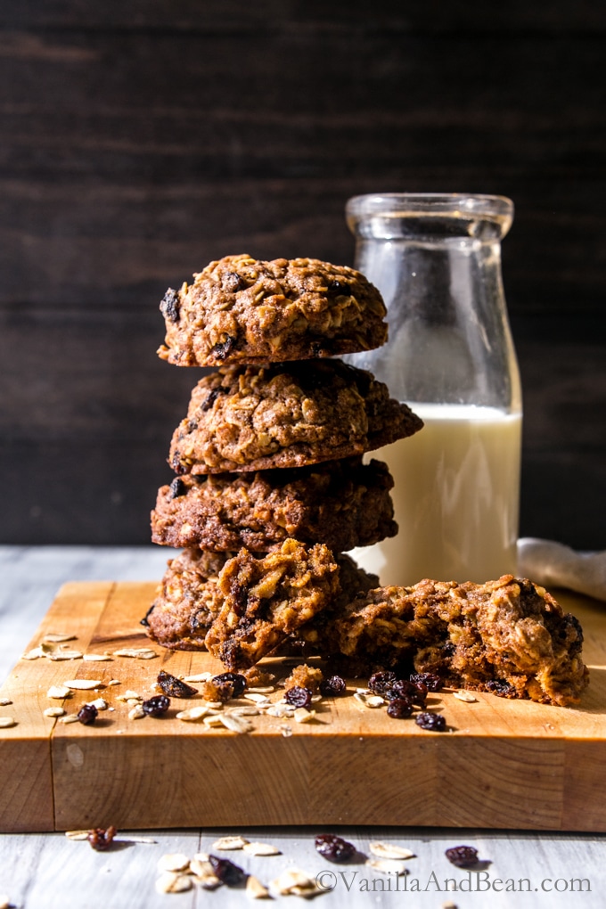 Teff Oatmeal Cookies with Whiskey Currants stacked tall with a jar of milk 