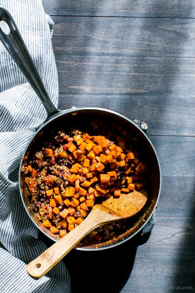 Sweet potatoes, black beans and quinoa in a pot with a spoon. 