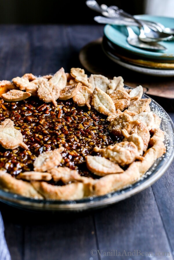 Vegan Bourbon Pecan Pie on a wood table ready for slicing and sharing.