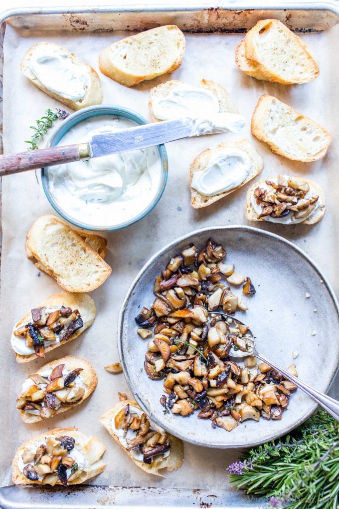 Mushroom crostini, sliced baguette, whipped goat cheese and mushrooms on a sheet pan.