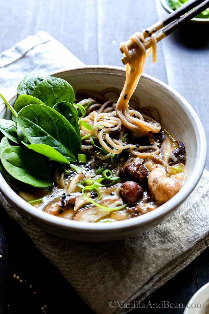 Speedy Miso Spinach Mushroom Ramen in a bowl with chop sticks picking up noodles.