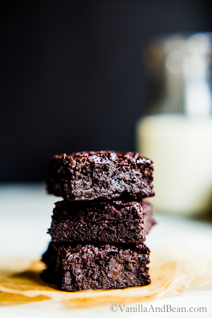 Chocolate Hazelnut Brownies stacked three high with a glass of milk in the background.