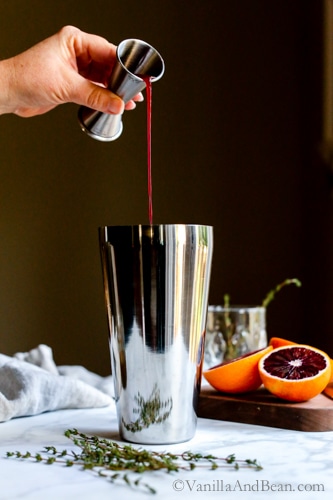 Pouring blood orange juice into a cocktail shaker. 