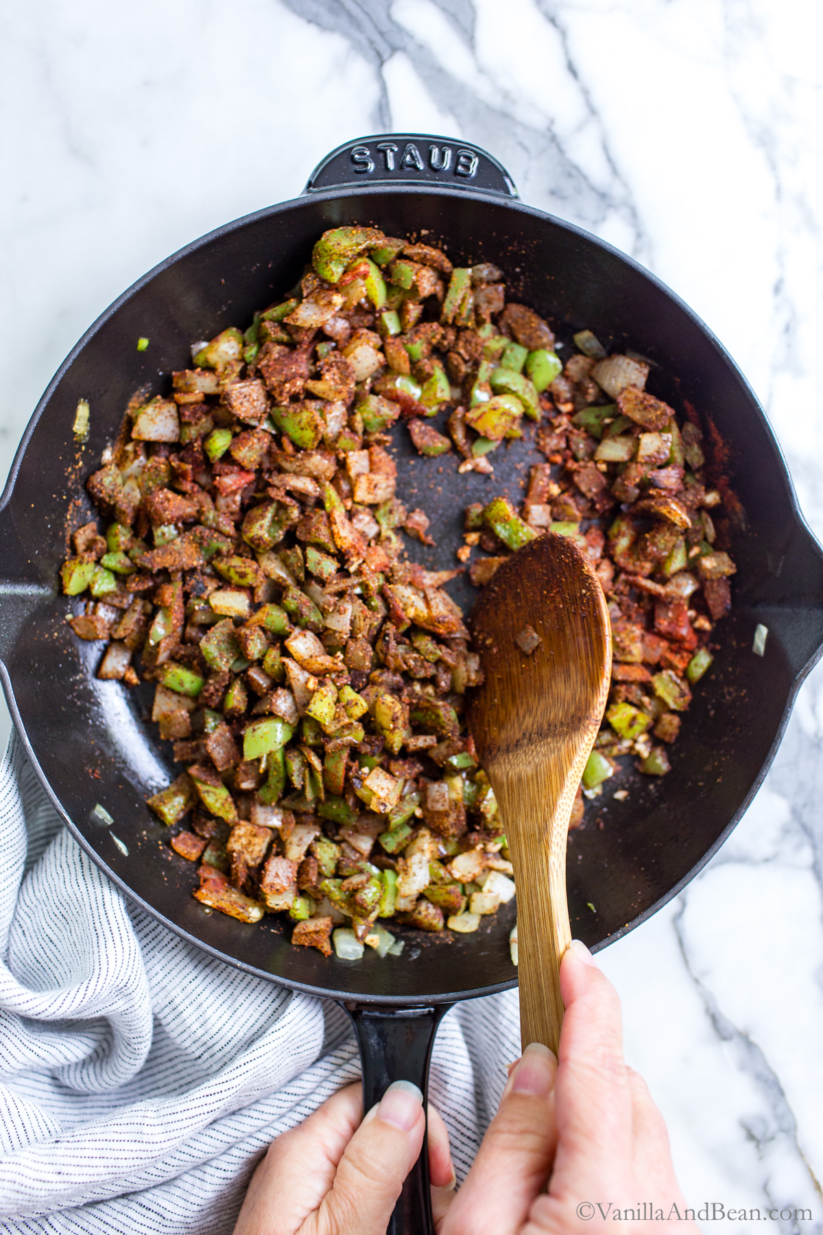 Onions, bell pepper and seasonings in a skillet, the base for vegetarian lentil sloppy joes.
