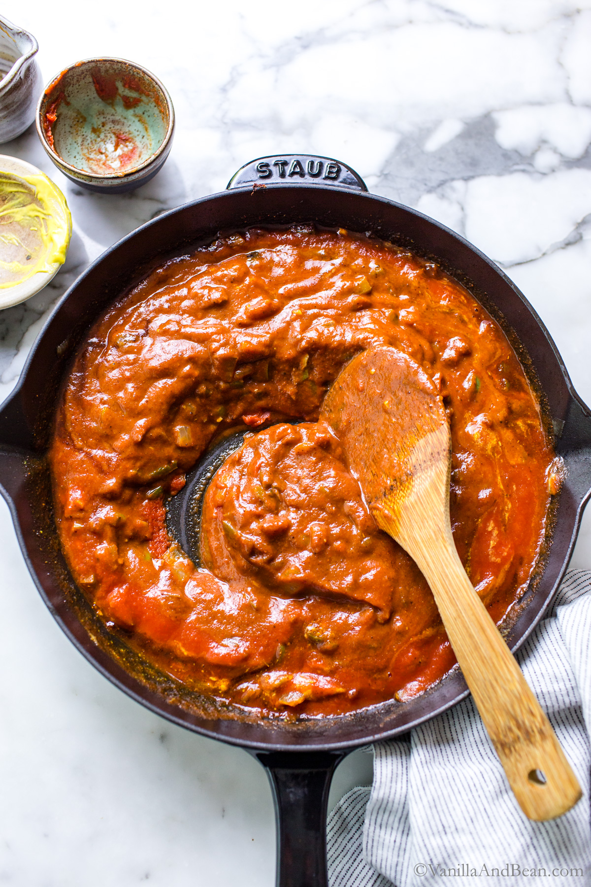 Veggie sloppy joe sauce in a skillet with a wood spoon.