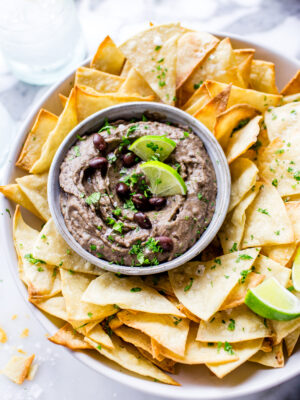 Mexican Black Bean Dip in a serving bowl with tortilla chips surrounding it.