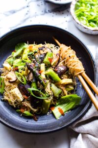 Garlic Asparagus Mushroom and Boc Choy Noodles in a bowl with chopsticks.