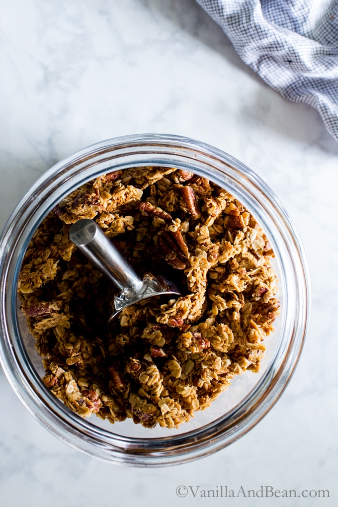 Maple Pecan Granola in a large cookie jar with a scoop.