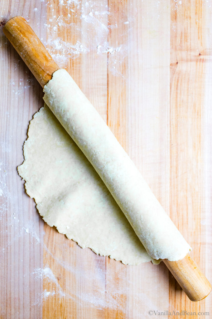 Butter pie dough rolled up on a rolling pin.